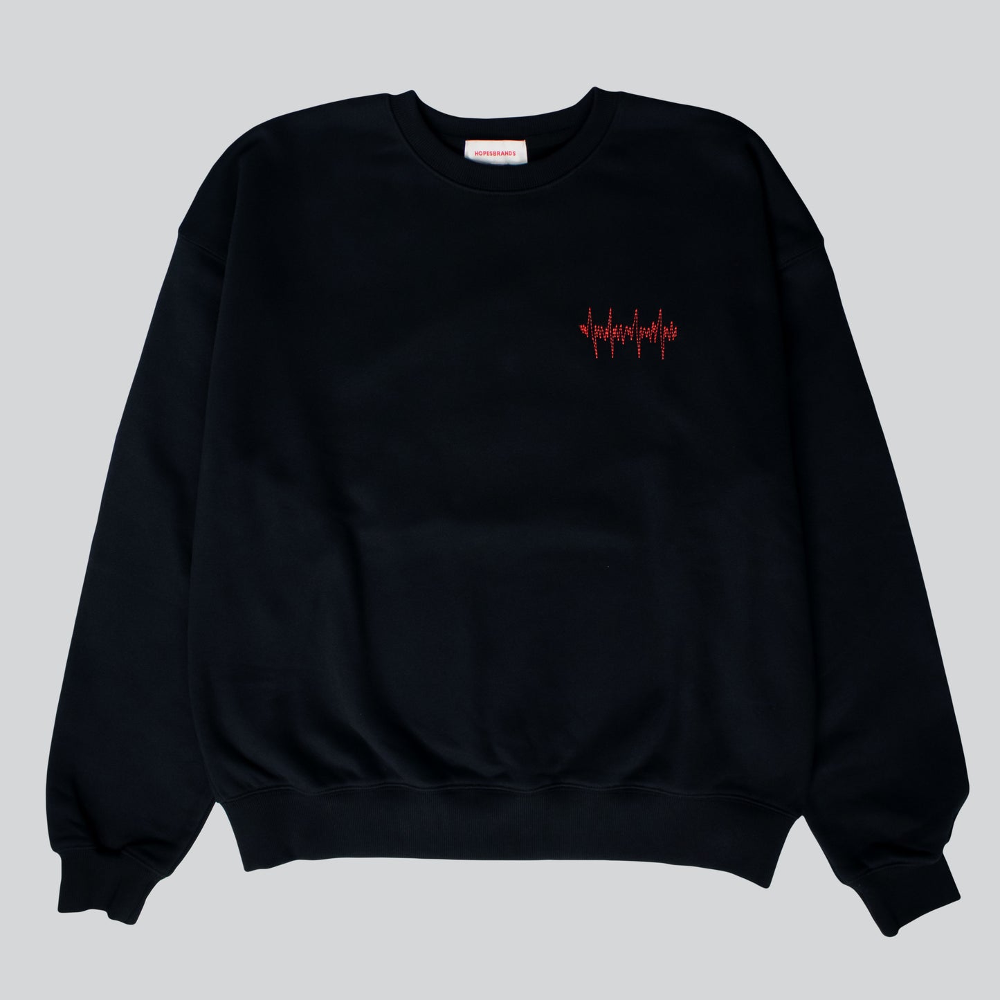 Product shot of the Hopesbrands Big Heart crewneck sweatshirt in black, featuring red lifeline stitches on the left chest and crafted from a comfortable cotton blend.