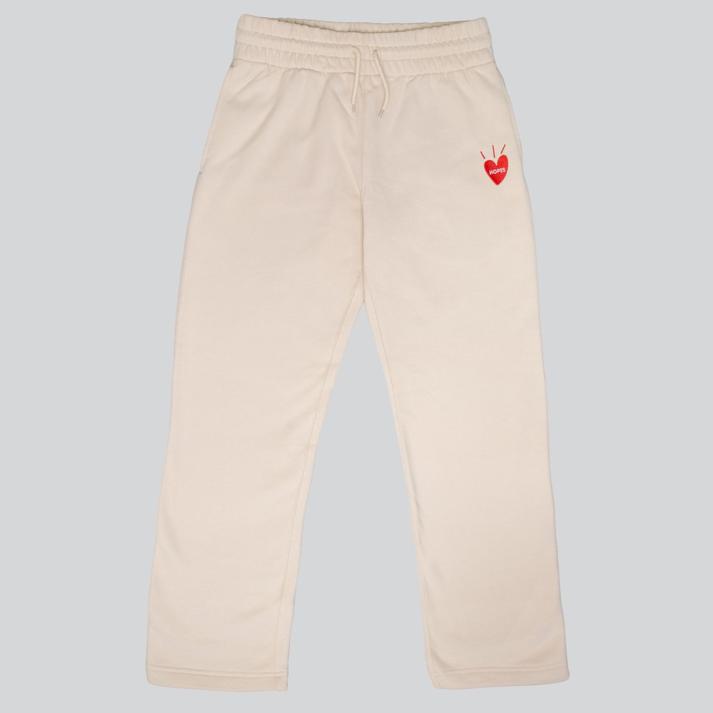 Product shot of Hopesbrands tan Big Heart sweatpants, crafted from a soft cotton blend. These unisex sweatpants feature an embroidered Big Heart logo on the right thigh, combining style and comfort for everyday wear.